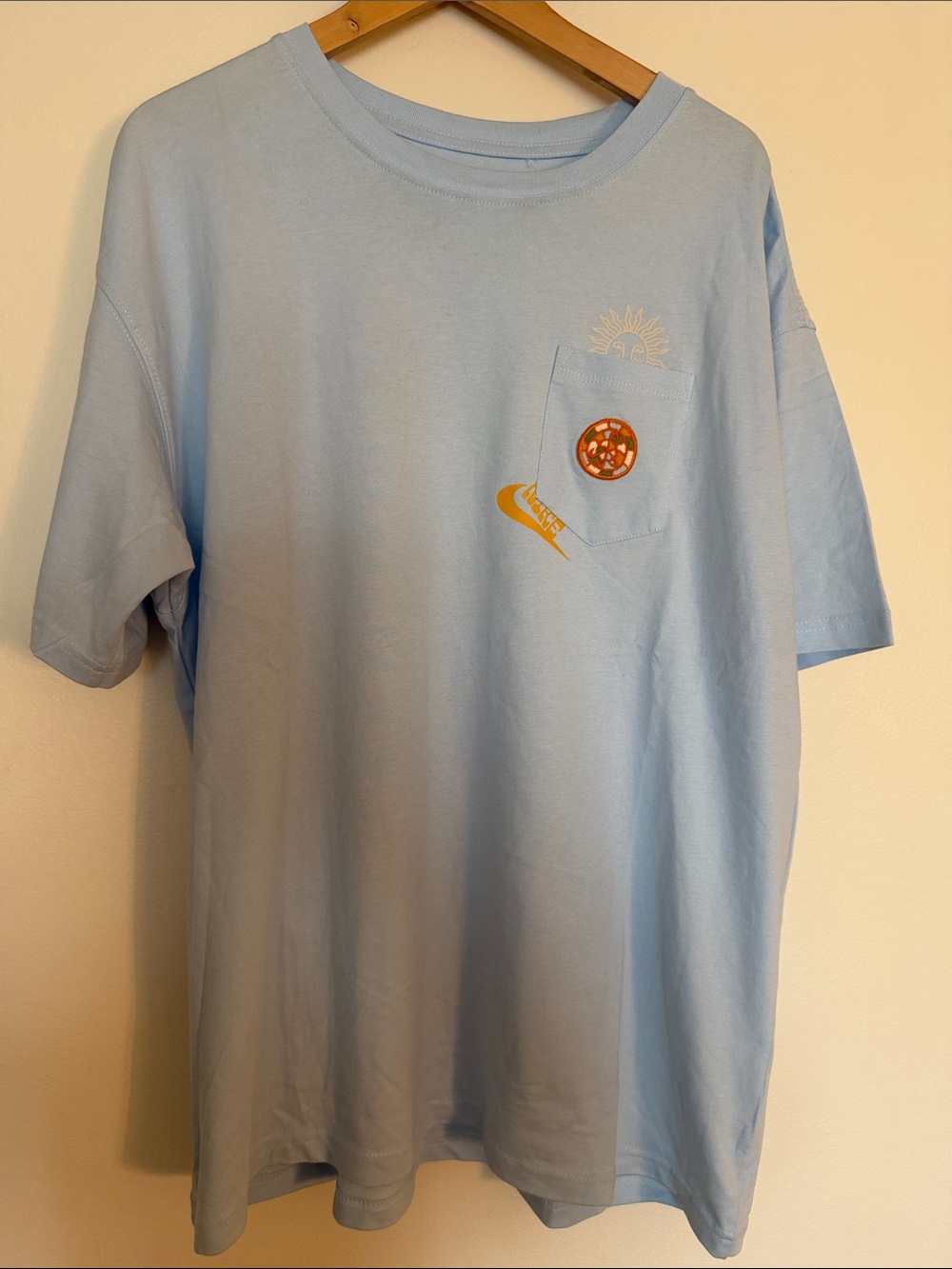 Nike Light Blue Short Sleeve Pocket Tee with Sun & Swoosh Graphic